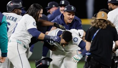 Seattle Mariners players celebrate with Jorge Polanco, center, after he hit the game-winning RBI single in the 15th inning in Game 5 of baseball