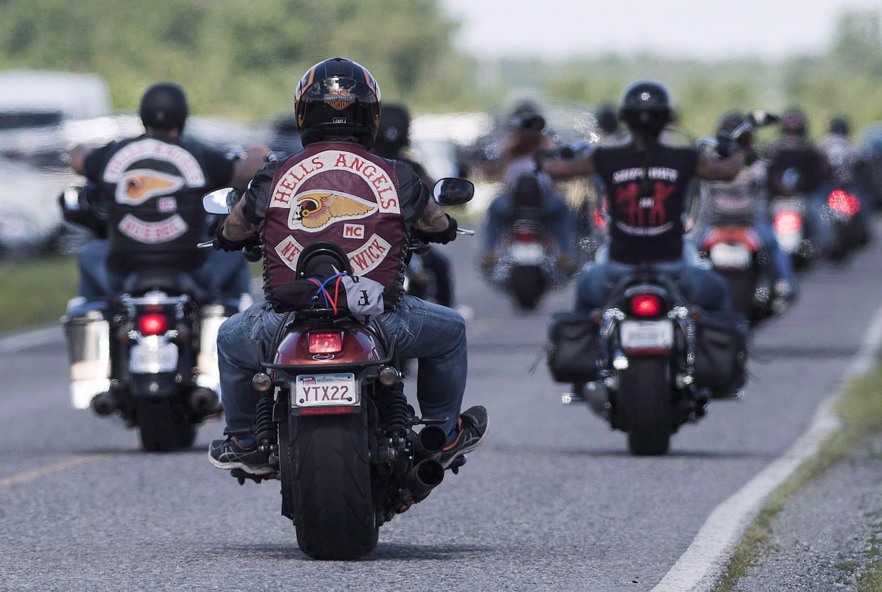 Multiple Hells Angels' ride togthere on an open road. 