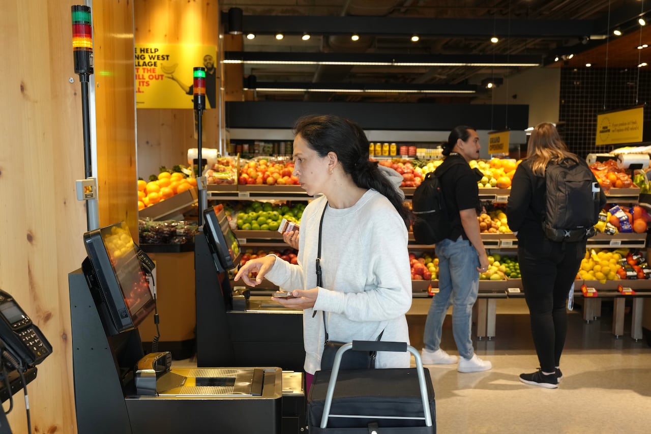 A customer stands at a self checkout counter