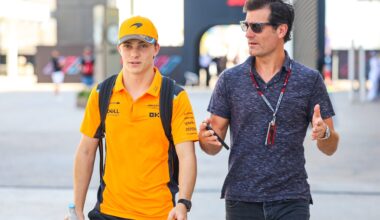 Piastri and manager Mark Webber walk the F1 paddock chatting