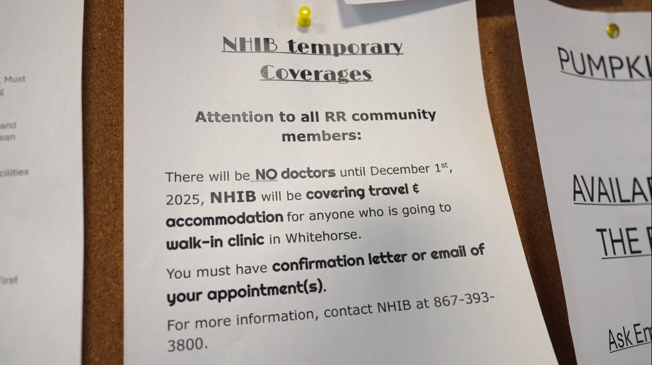 A white paper sign pinned on a bulleting board.