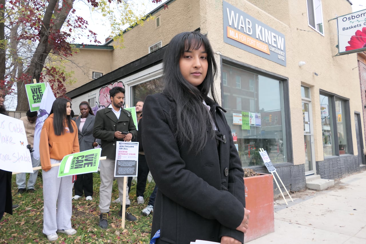 A woman standing in front of people holding signs.