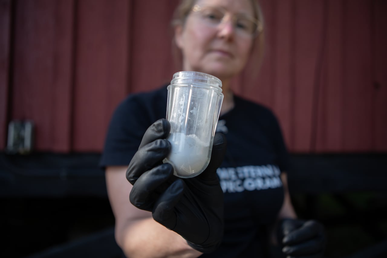 A woman holds a container filled with white powder