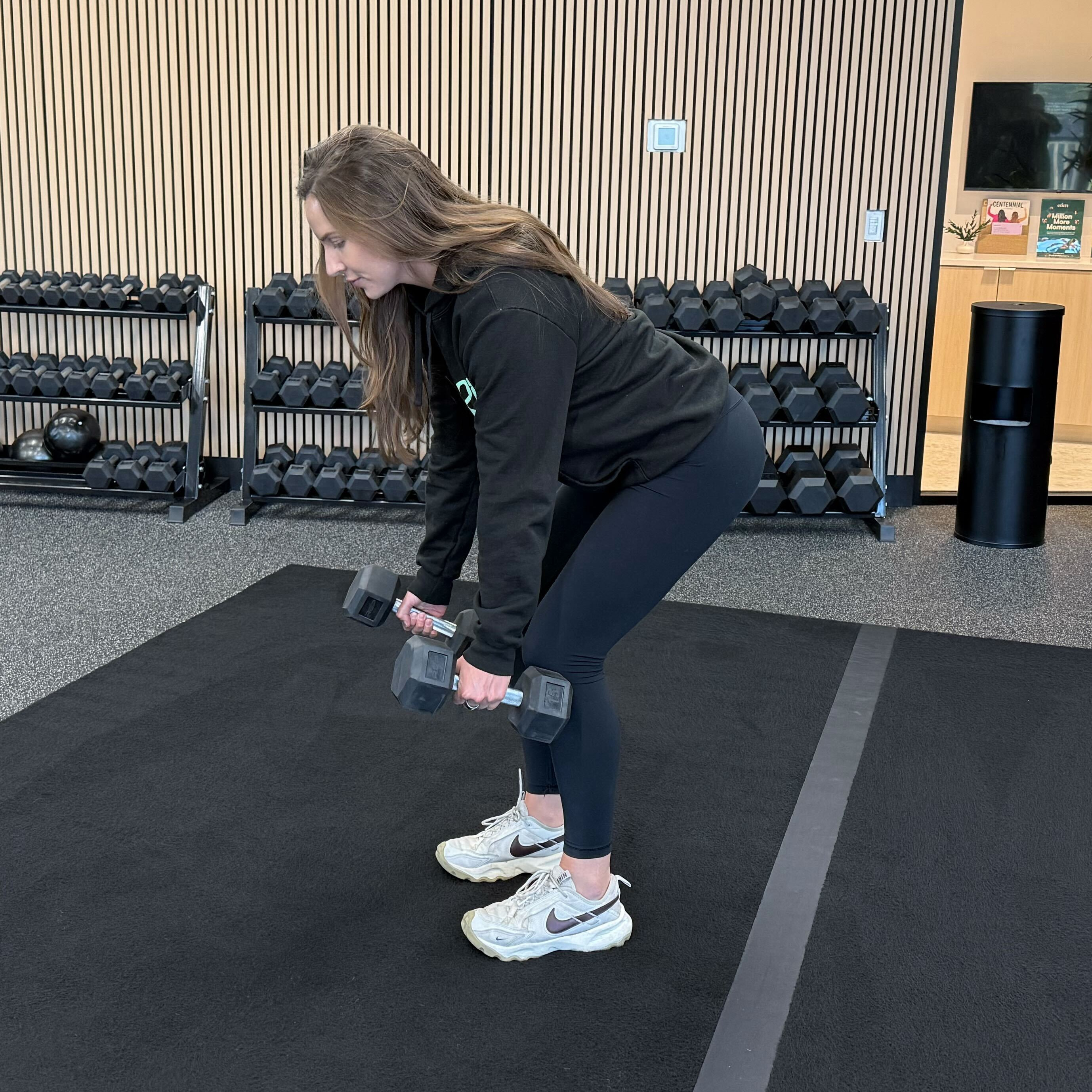 Felicia Hernandez, a personal trainer for Eden Health Club, perform a bent over row in a fitness studio.