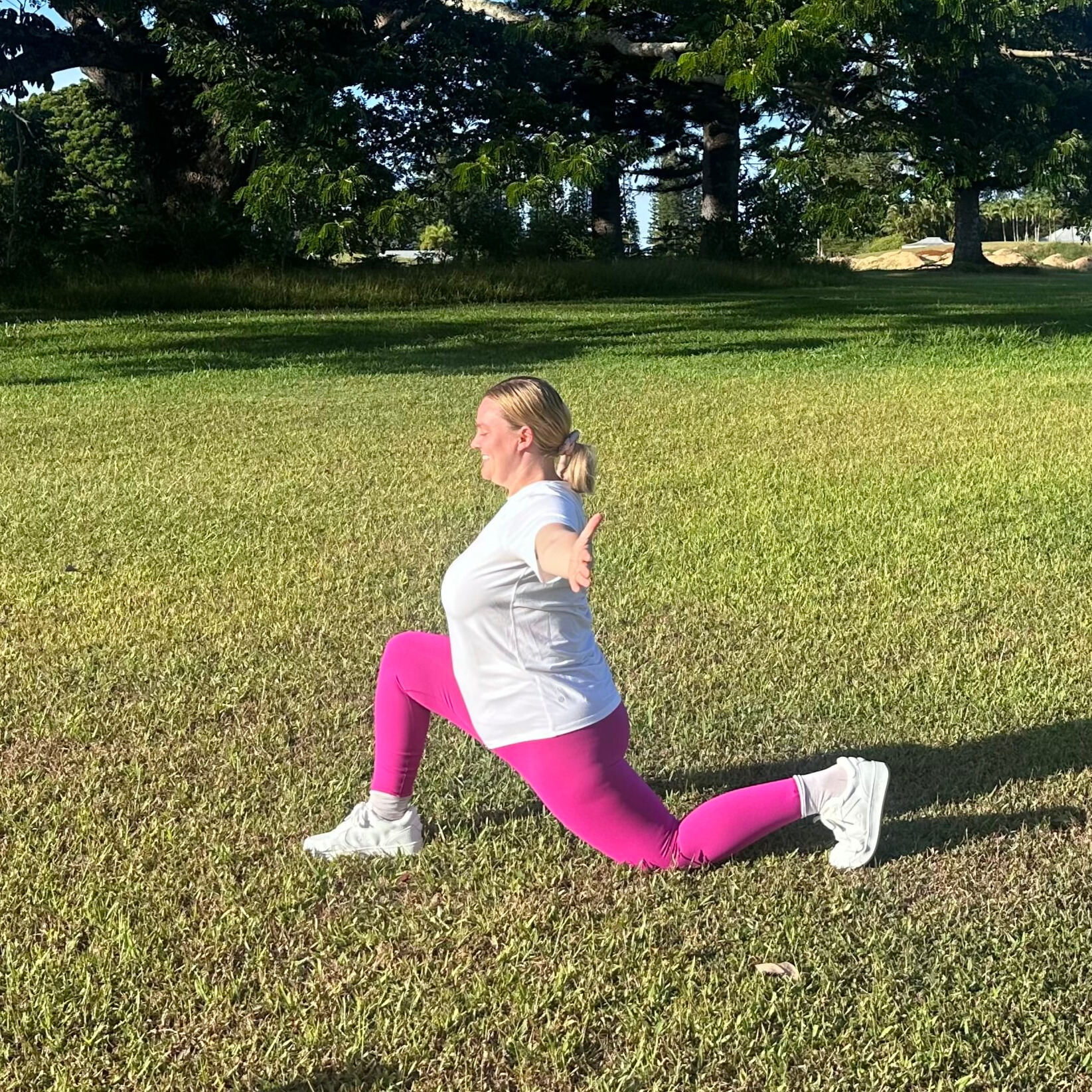 Woman demonstrating stretches on grass