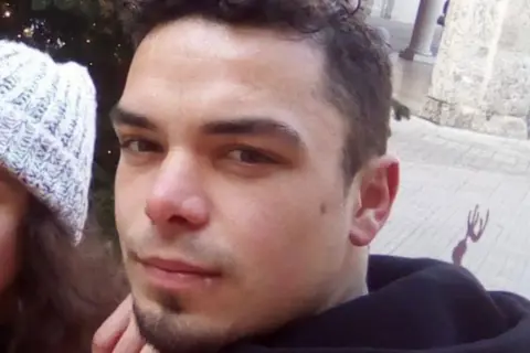 PA Media Close-up of Leonard Farruku looking at the camera. He has smartly cropped dark hair and a stubble goatee beard and has a serious expression.