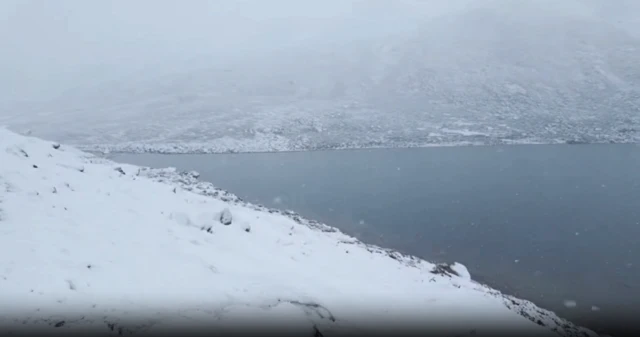 White snow falling on mountainous terrain