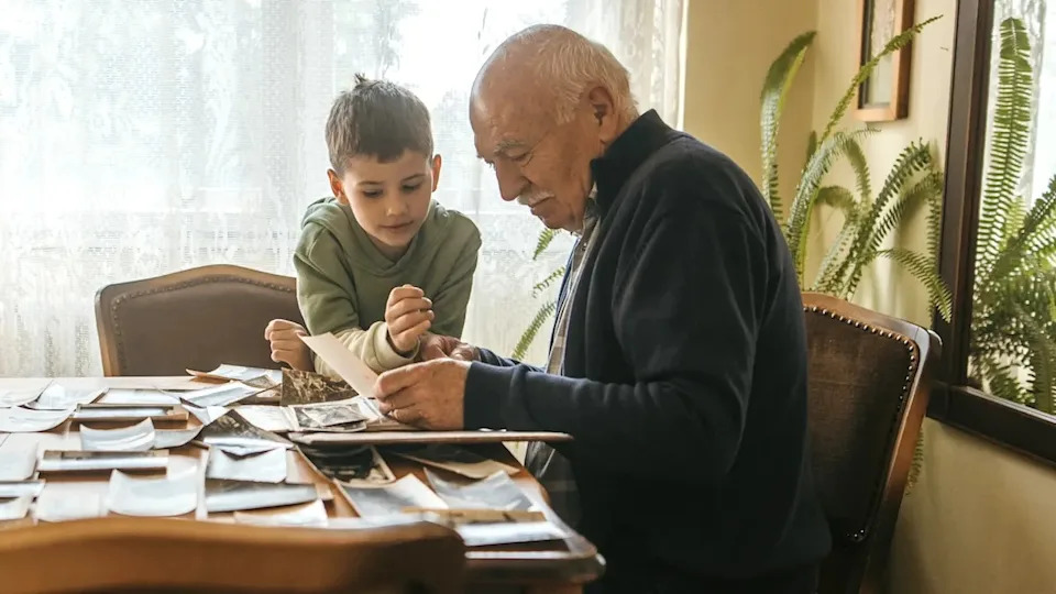 Senior man looking at pictures with grandson