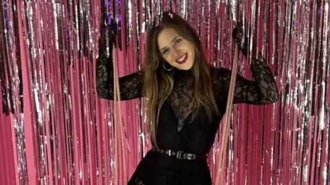 Jessica Rickards Jessica Rickards wearing black and sat on a pink swing