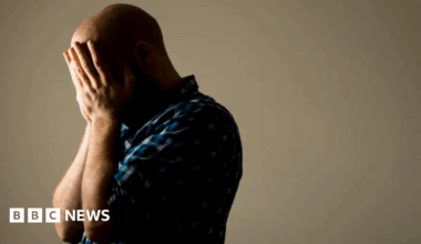 A stock image of a man with his head in his hands.