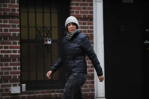 Getty Images/ New York Daily News Archive Ghislaine Maxwell wearing a gray hat and black jacket and jeans walks in front of a brick building looking to the side after leaving her East 65th Street townhouse in Manhattan on 04 January 2015