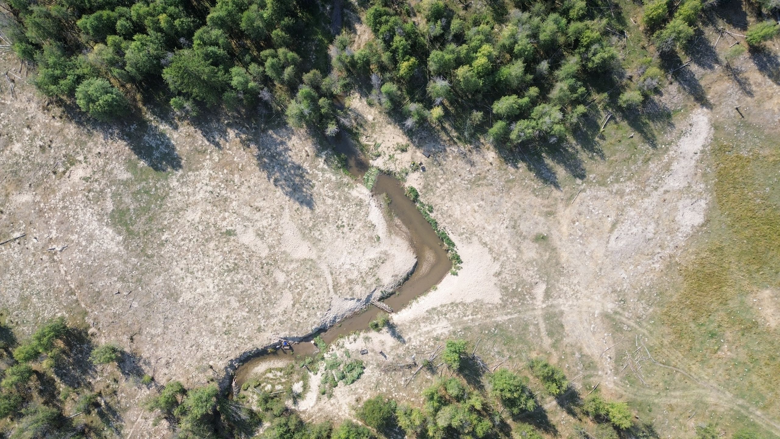An aerial view of Coteay Creek, looking downstream. Sparse trees populate either end of the creek.