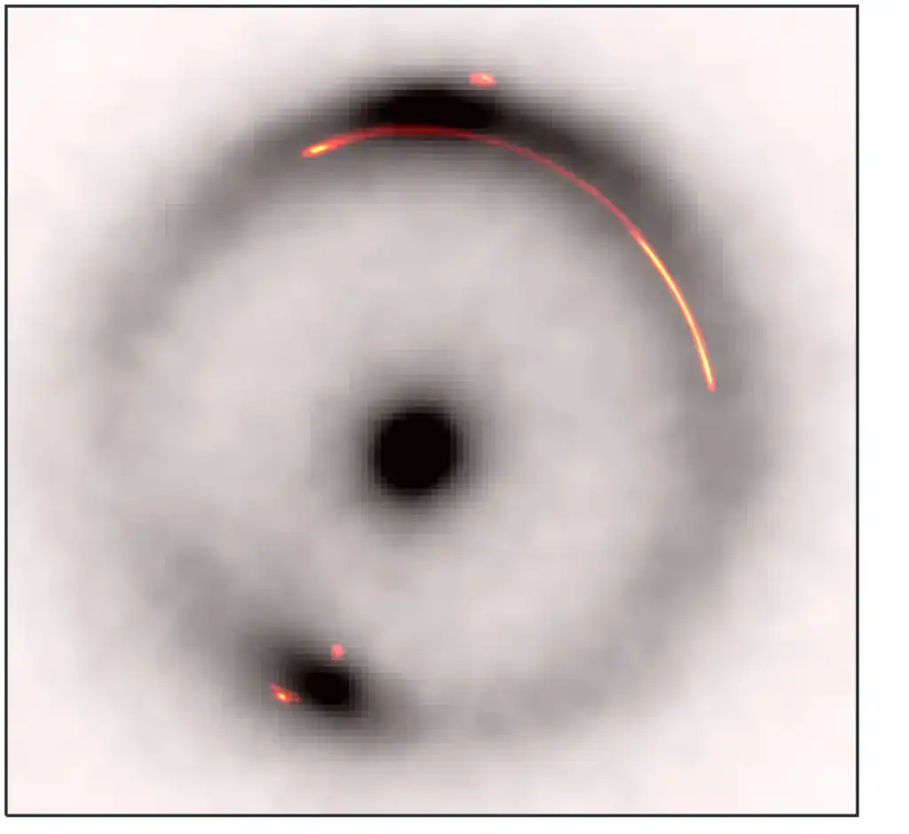 Overlay of the infrared emission (black and white) with the radio emission (colored). The dark, low-mass object is located at the gap in the bright part of the arc on the right hand side.