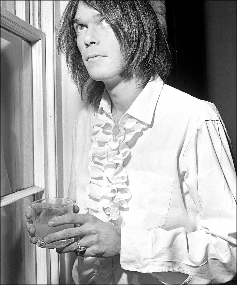 Neil Young standing in a window, 1970