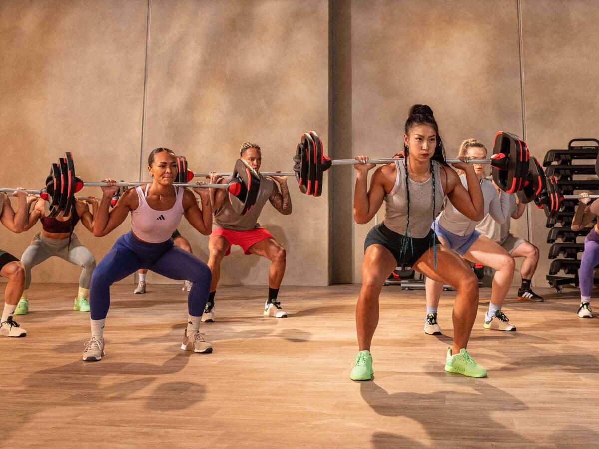 Group of exercisers squatting with a barbell