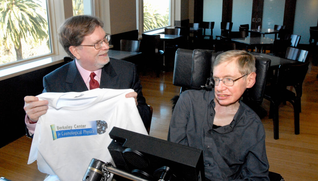 a man holding a T-shirt while talking with a man in a wheelchair