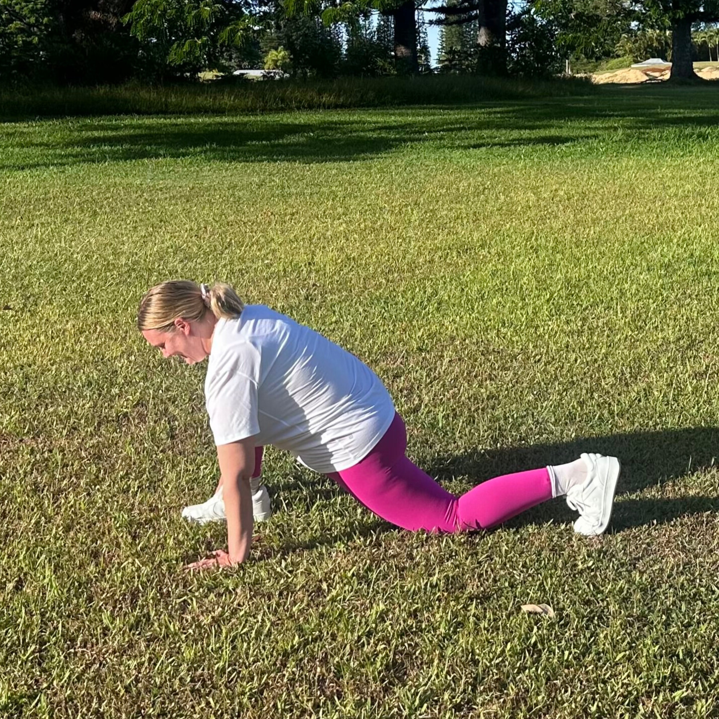 Woman demonstrating stretches on grass
