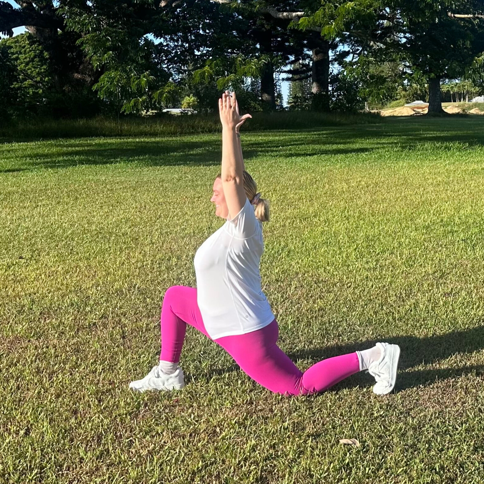 Woman demonstrating stretches on grass