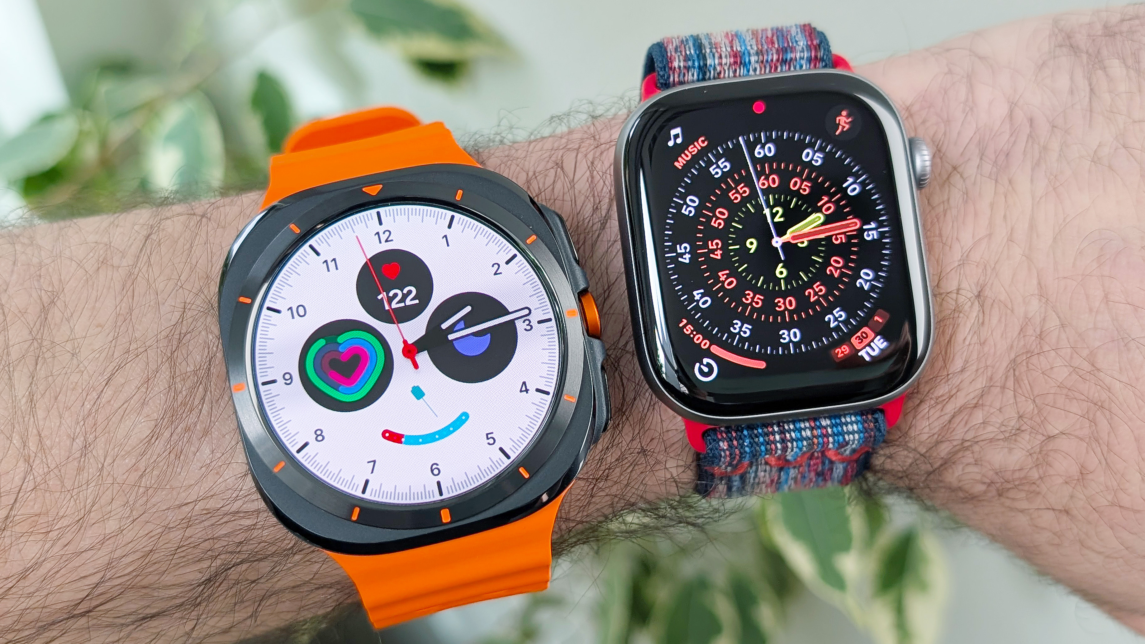Close-up of the Samsung Galaxy Watch Ultra and Apple Watch Series 11 on a user's wrist