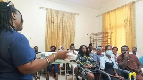 University Hospitals of Northamptonshire Eunice Vial speaking to a room of people in a clinical setting.