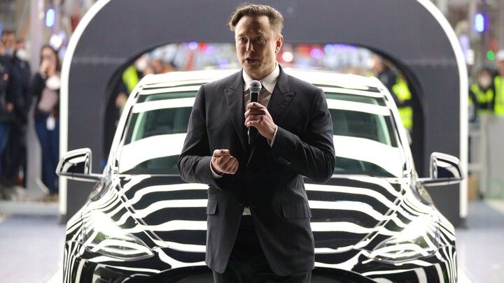 Elon Musk in front of a Tesla