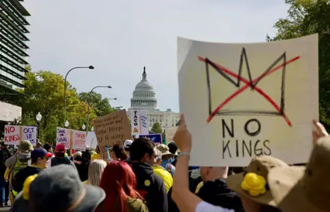 Getty Images Protestors march outside the Capitol building in Washington, DC. One person carries a sign that reads "No Kings".