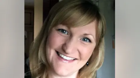 LinkedIn A photo of Karen Booth, smiling broadly with her head tilted. She has blonde hair with a sweeping fringe and the image is closely cropped showing her face and neck.