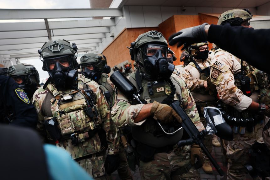Federal agents, including members of the Department of Homeland Security, the Border Patrol, and police, attempt to keep protesters back outside a downtown US Immigration and Customs Enforcement (ICE) facility in Portland, Oregon, on October 4, 2025.