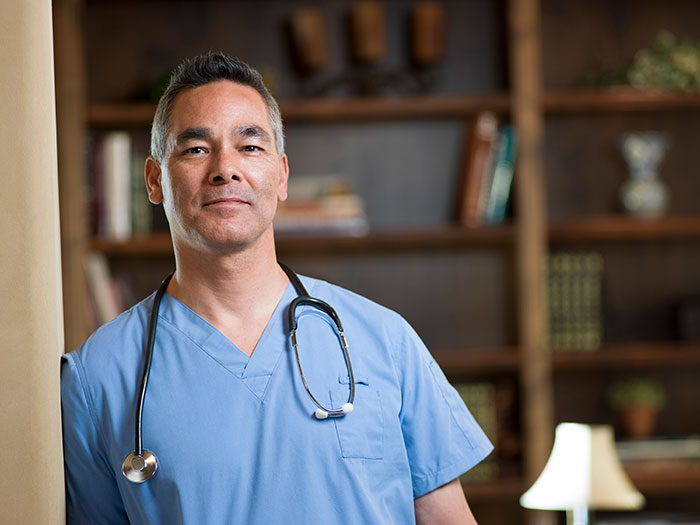 Doctor in blue scrubs with stethoscope, representing medical professionals correcting self-diagnosed health mistakes.