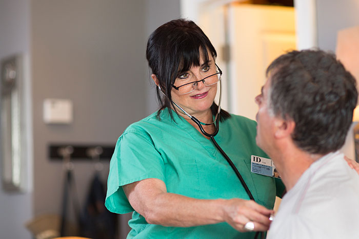 Female doctor using stethoscope to examine male patient, illustrating self-diagnosed health misconceptions corrected by professionals.