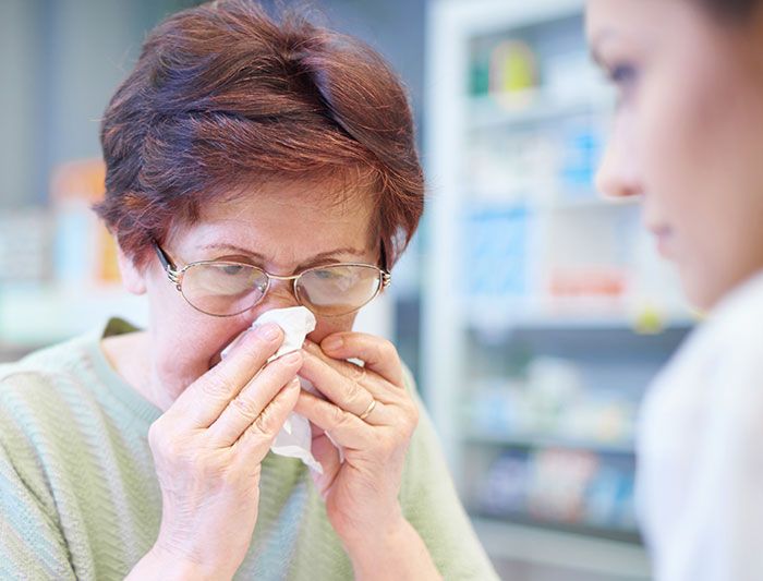 Older woman self-diagnosing her illness while consulting a medical professional in a clinical setting about her symptoms.