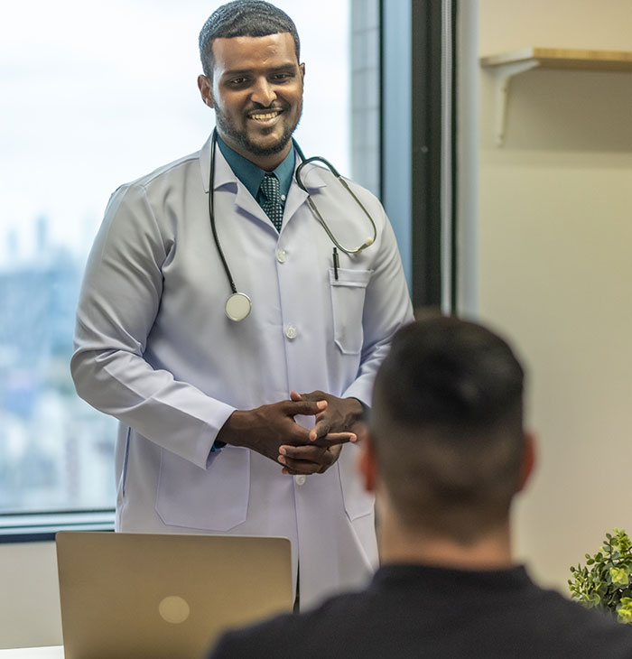 Doctor with stethoscope talking to patient in clinic, illustrating common cases of self-diagnosed medical errors.