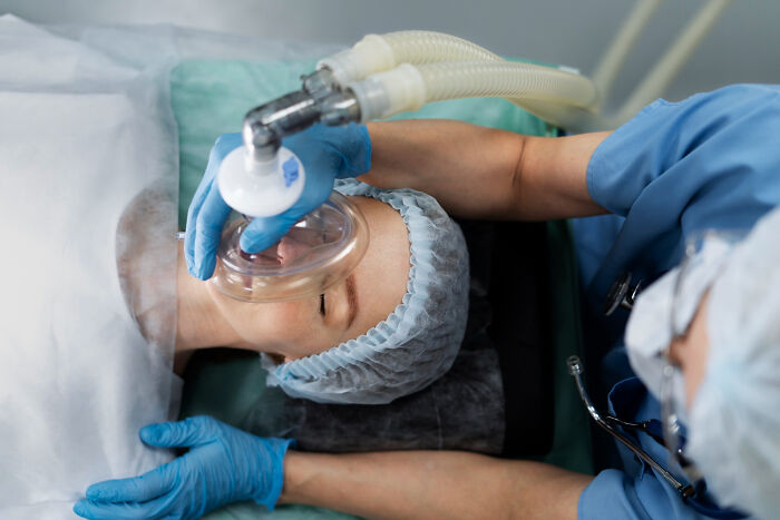 Patient receiving oxygen mask from doctor in hospital setting highlighting terrifying symptoms ignored by patients.