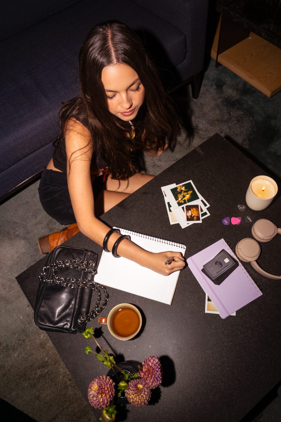 olivia rodrigo sitting down and writing in a notebook