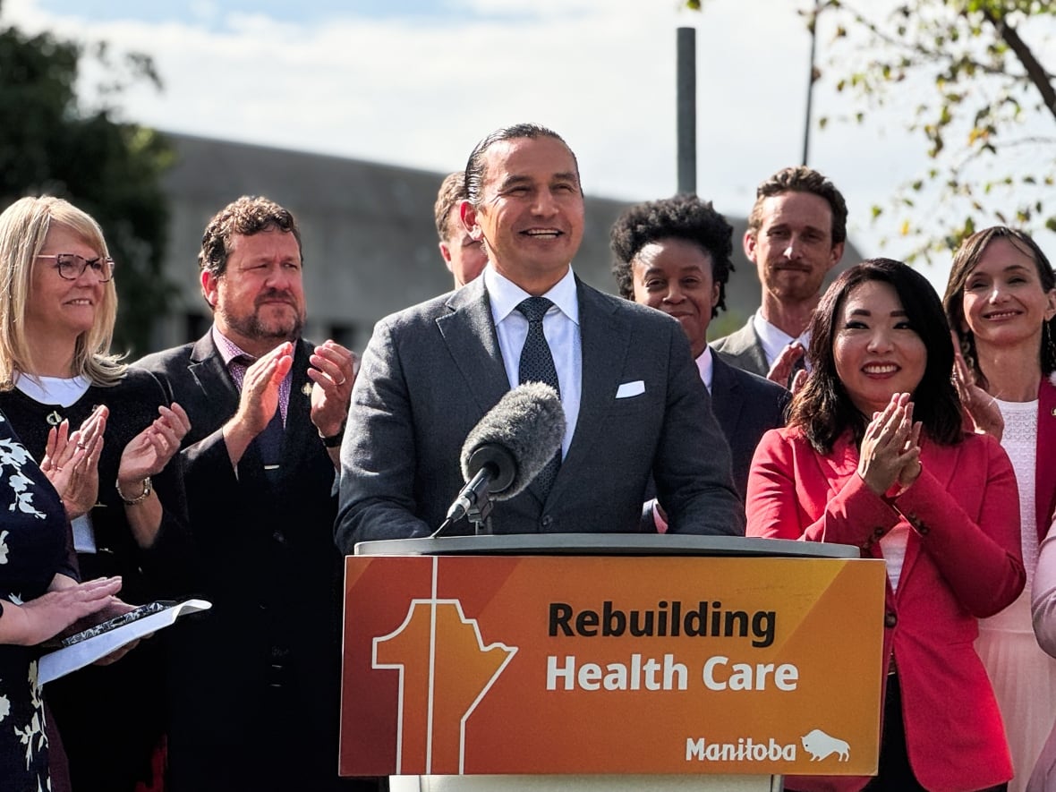 A man stands in front of a group of people.