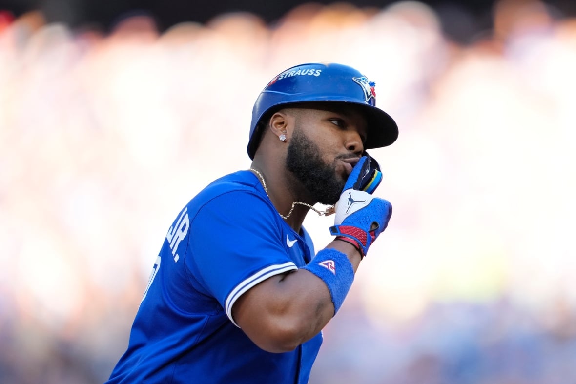 A baseball player points upward.
