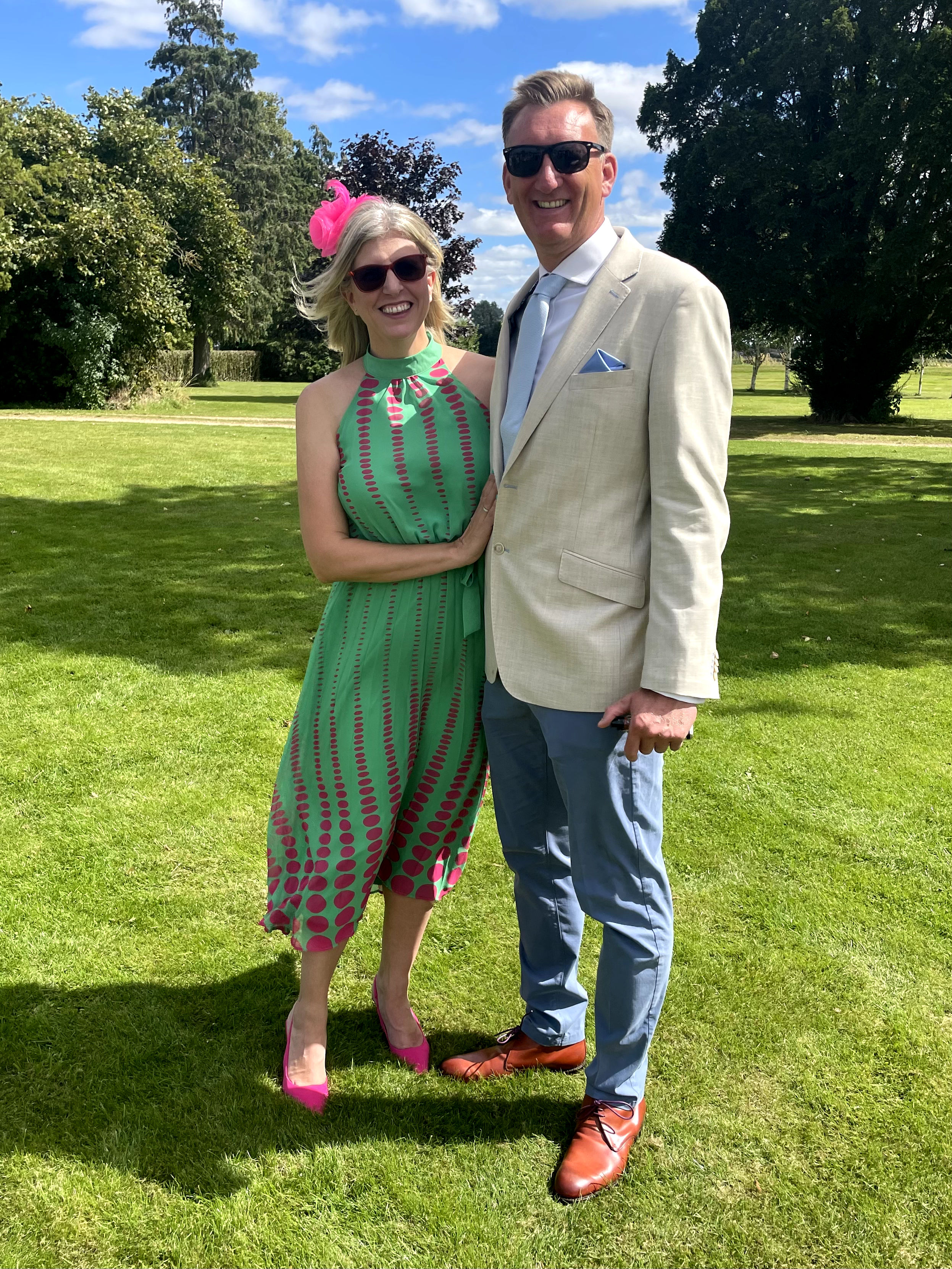 Caroline Raines and Marc Sumner, her partner, posing for a picture in a grassy outdoor area.