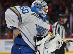 St. Louis Blues goalie Jordan Binnington attempts to hide the puck in his pads of NHL career goal 900 by Washington Capitals' Alex Ovechkin.