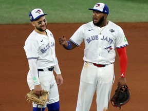 Vladimir Guerrero Jr. (right) and Bo Bichette of the Toronto Blue Jays talk during a pitching change against the Los Angeles Dodgers.