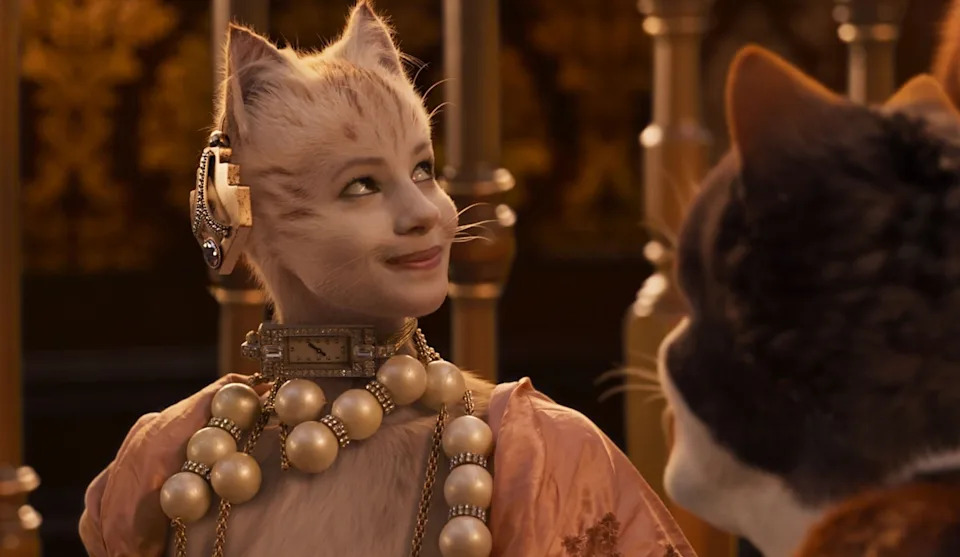 Cat character in ornate, pearl-adorned costume, looking at another cat in a scene