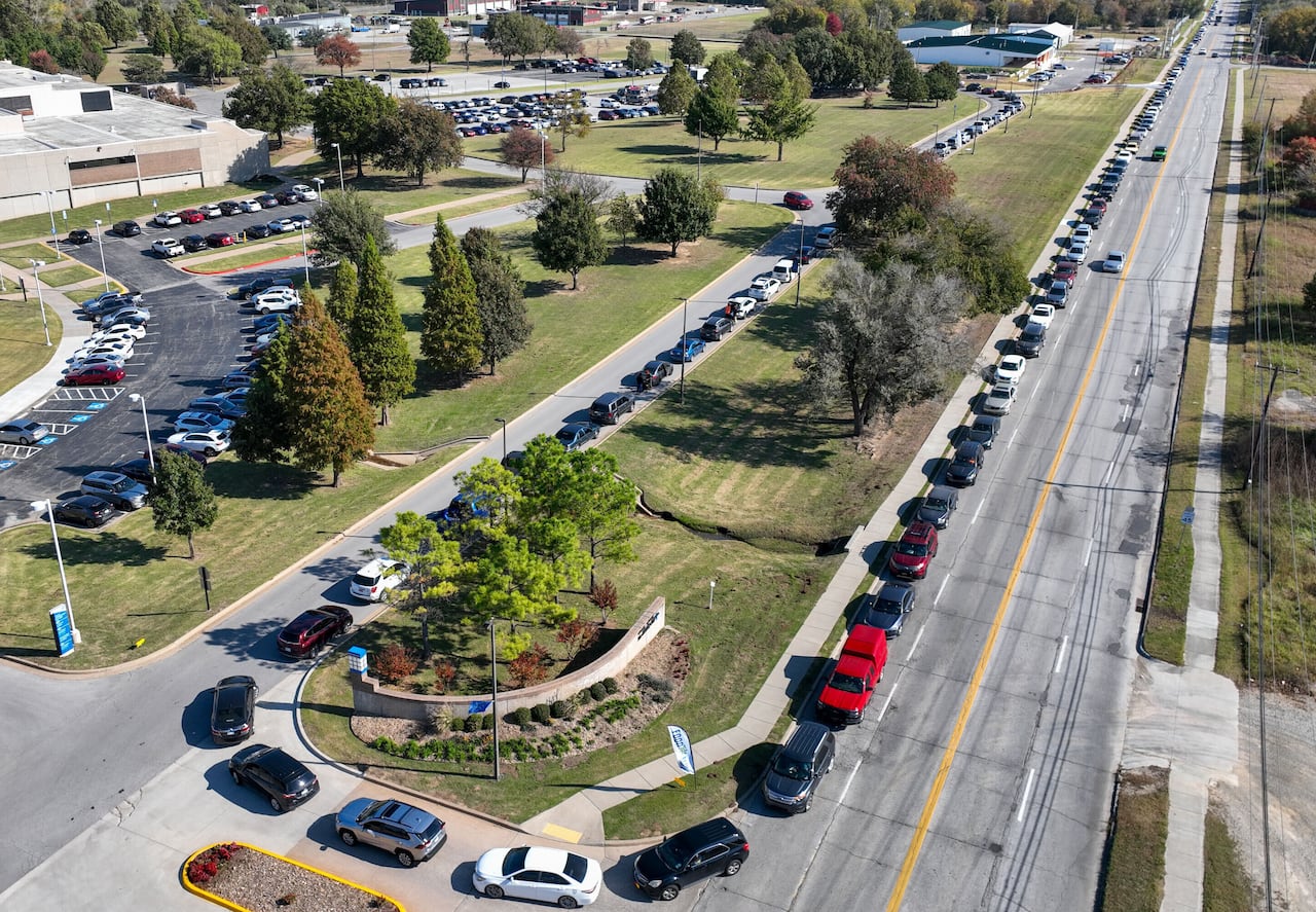 An aerial view shows a long line of cars lining up.