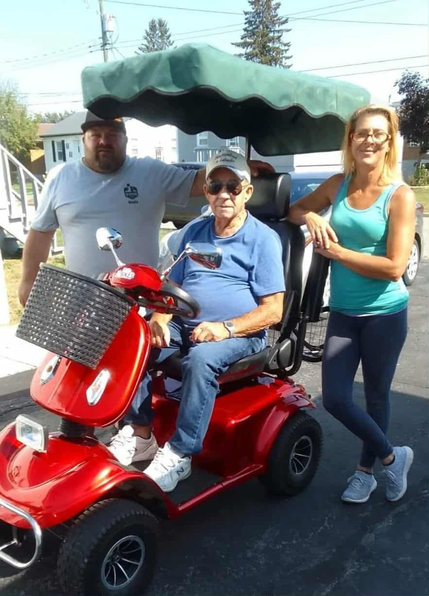 three people standing around a golf cart 
