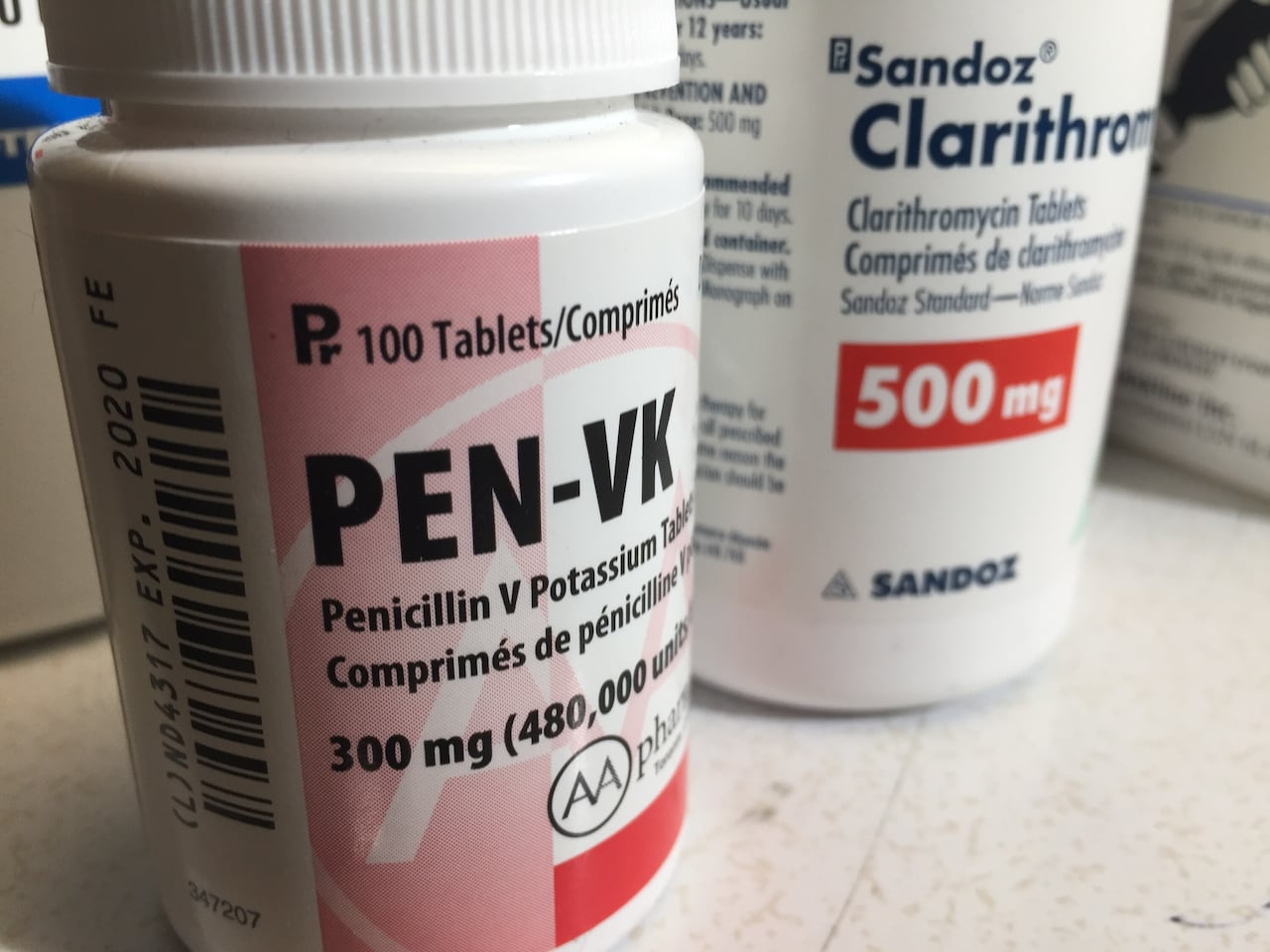 Two bottles of Penicillin and Clarithromycin antibiotic tablets are pictured in closeup. 
