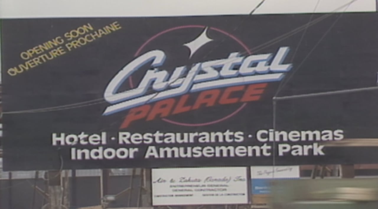 A black sign that says "Crystal Palace | Hotel Restaurants Cinemas Indoor Amusement Park" with "Opening Soon" written in the top left corner. 
