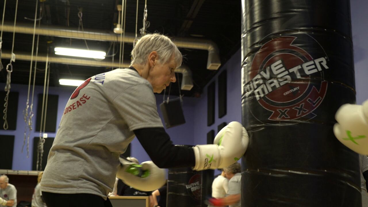 Linda Moore hits a punching bag. She told CBC News the exercises she's done during KOPD classes have allowed her to stand taller, something many patients struggle with.