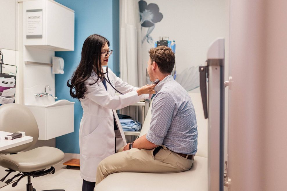 A Dr uses a stethoscope on a patient.