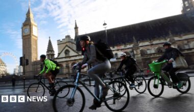 Cyclists ride past Parliament during rush hour in London, on 28 October 2025