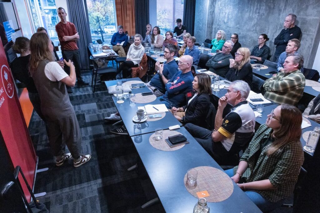 A group of people in a conference room listening to a presentation.
