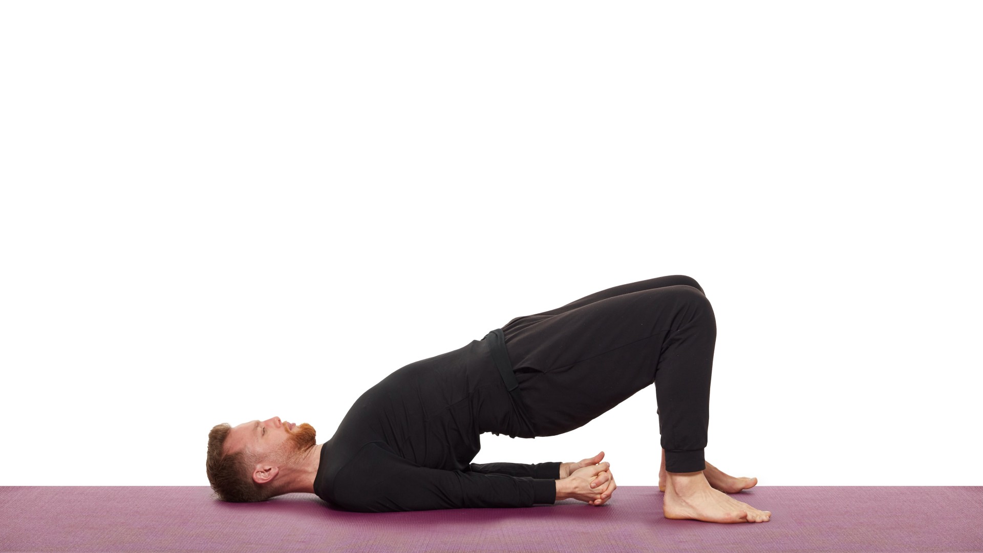 Nick Higgins demonstrating bridge pose on his yoga mat