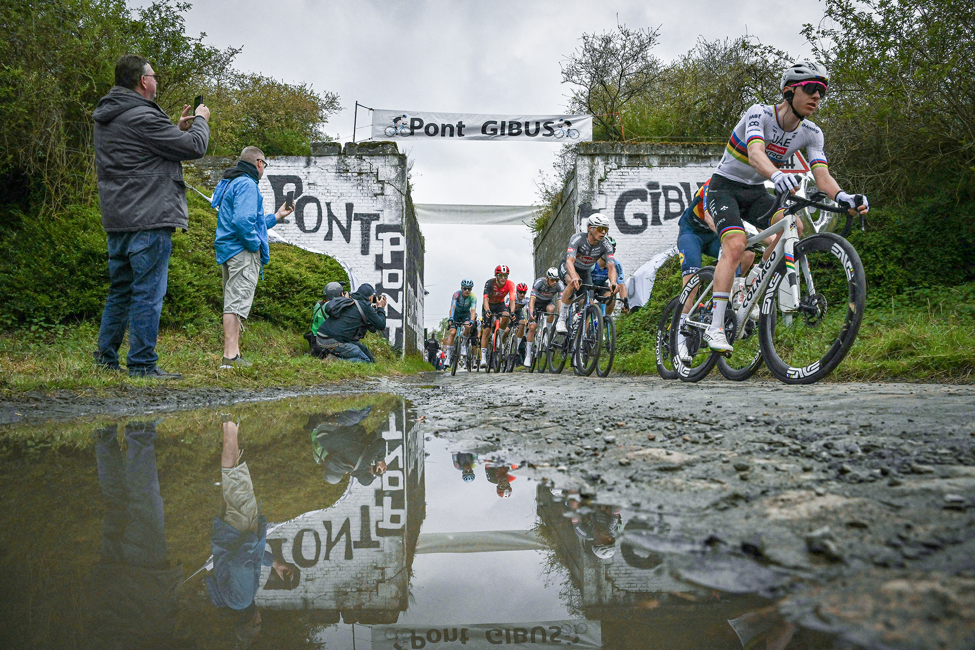 TOPSHOT - UAE Team Emirates' Slovenian rider Tadej Pogacar (R) cycles past the Pont Gibus in a cobblestone sector during the 122nd edition of the Paris-Roubaix one-day classic cycling race, 259,2 km between Compiegne and Roubaix, northern France on April 13, 2025. (Photo by Jeff PACHOUD / AFP) (Photo by JEFF PACHOUD/AFP via Getty Images)